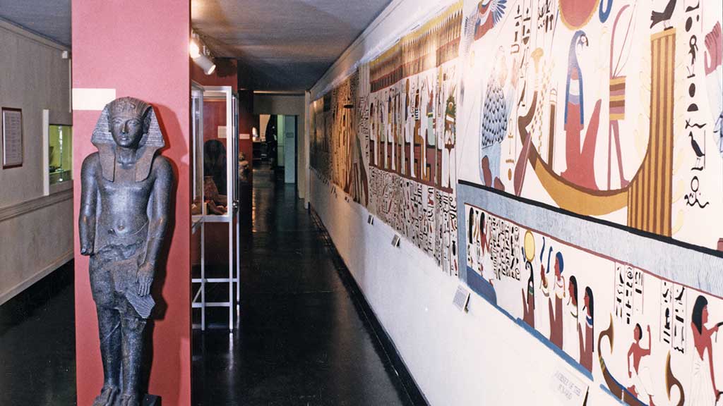 long hallway with an Egyptian statue and mural