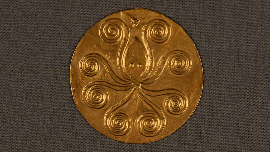 small gold disc with embossed octopus design