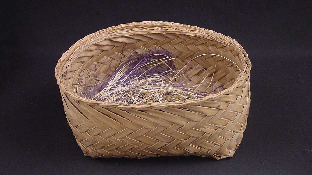 small round women basket filled with purple and cream colored fibers