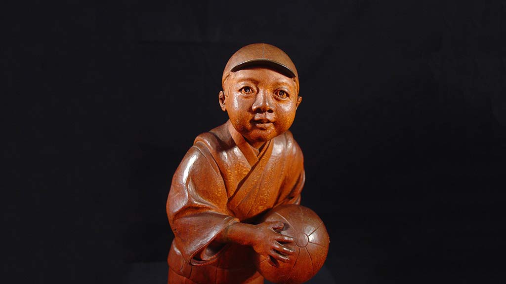 carved boy holding a volleyball