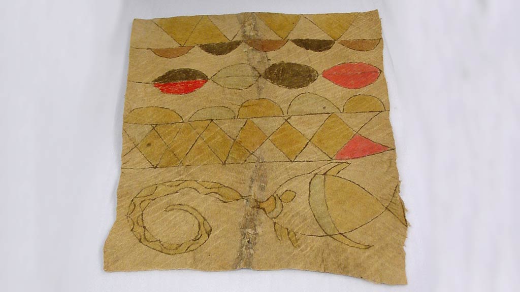 square bark cloth with gold, brown, and bright red designs