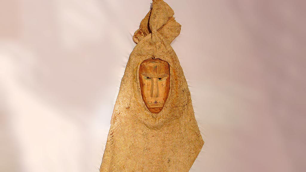 triangular bark cloth mask with human-looking wooden face