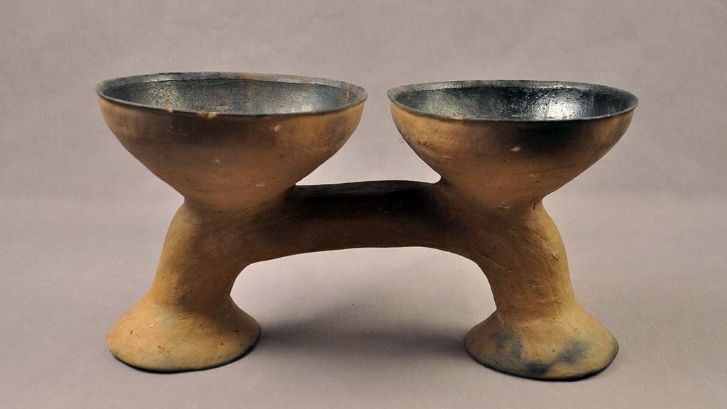 two earthenware bowls connected by a stand