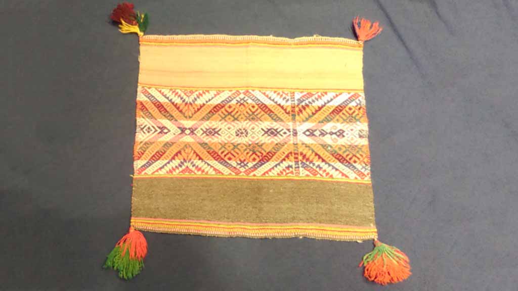 fabric placemat with tassle decorations at corners