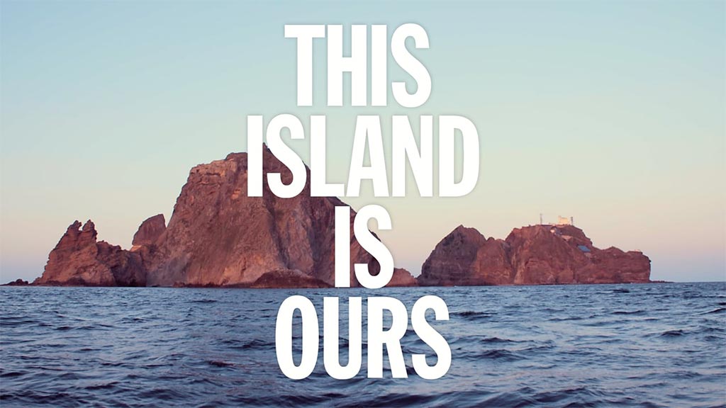 This Island Is Ours title over a mountainous landscapre rising from a sea.