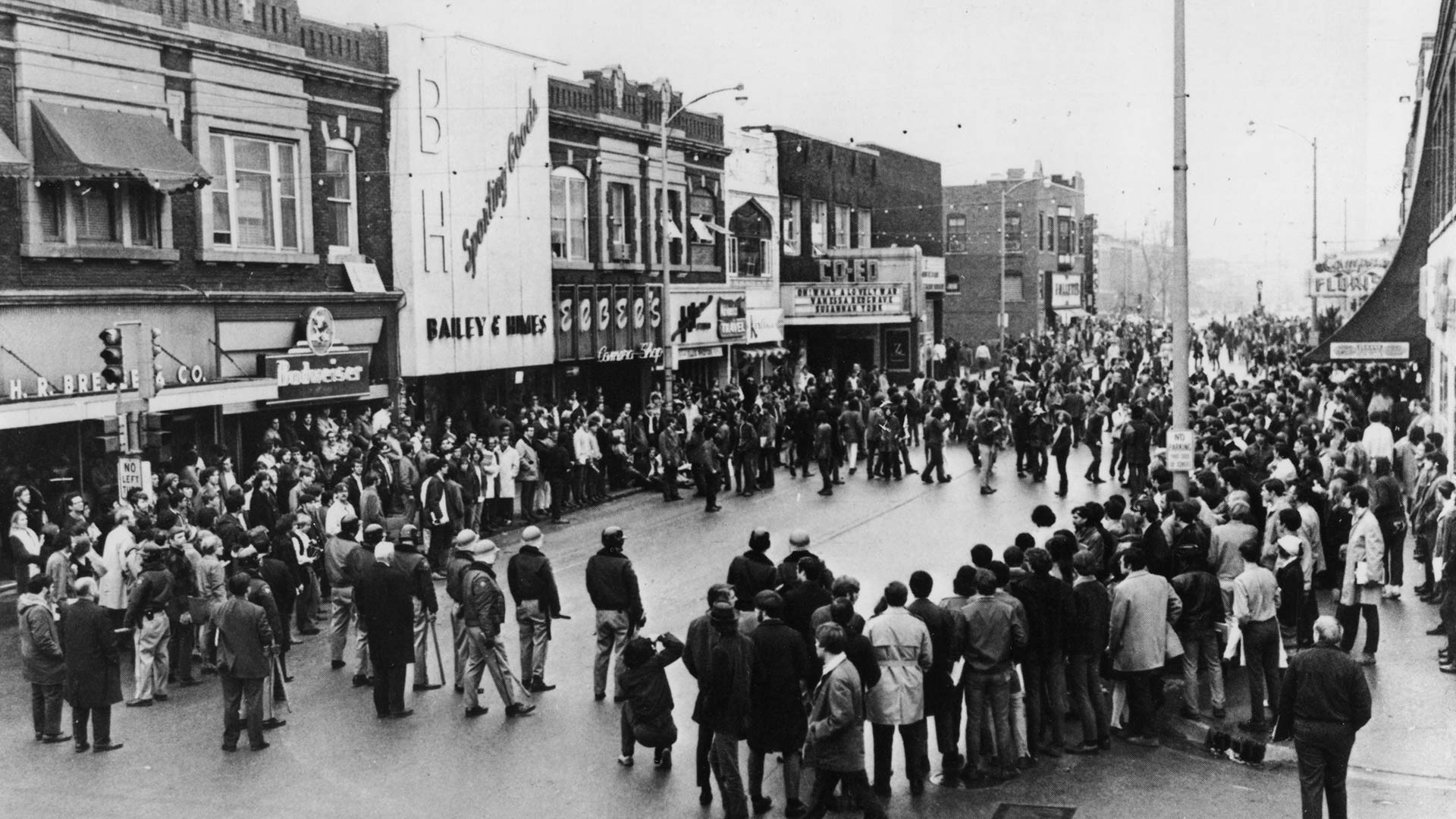 a large crowd of people and police officers in the middle of Green Street in 1970