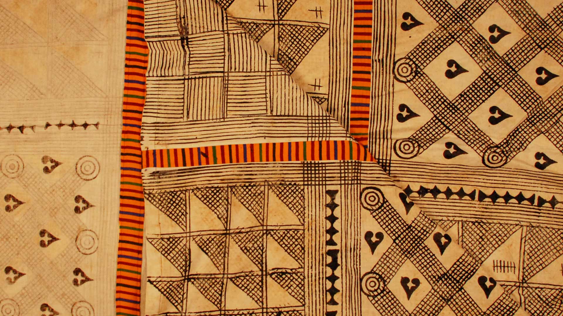 a fabric painting with crisscross patterns drawn in black, bordered with orange patterns