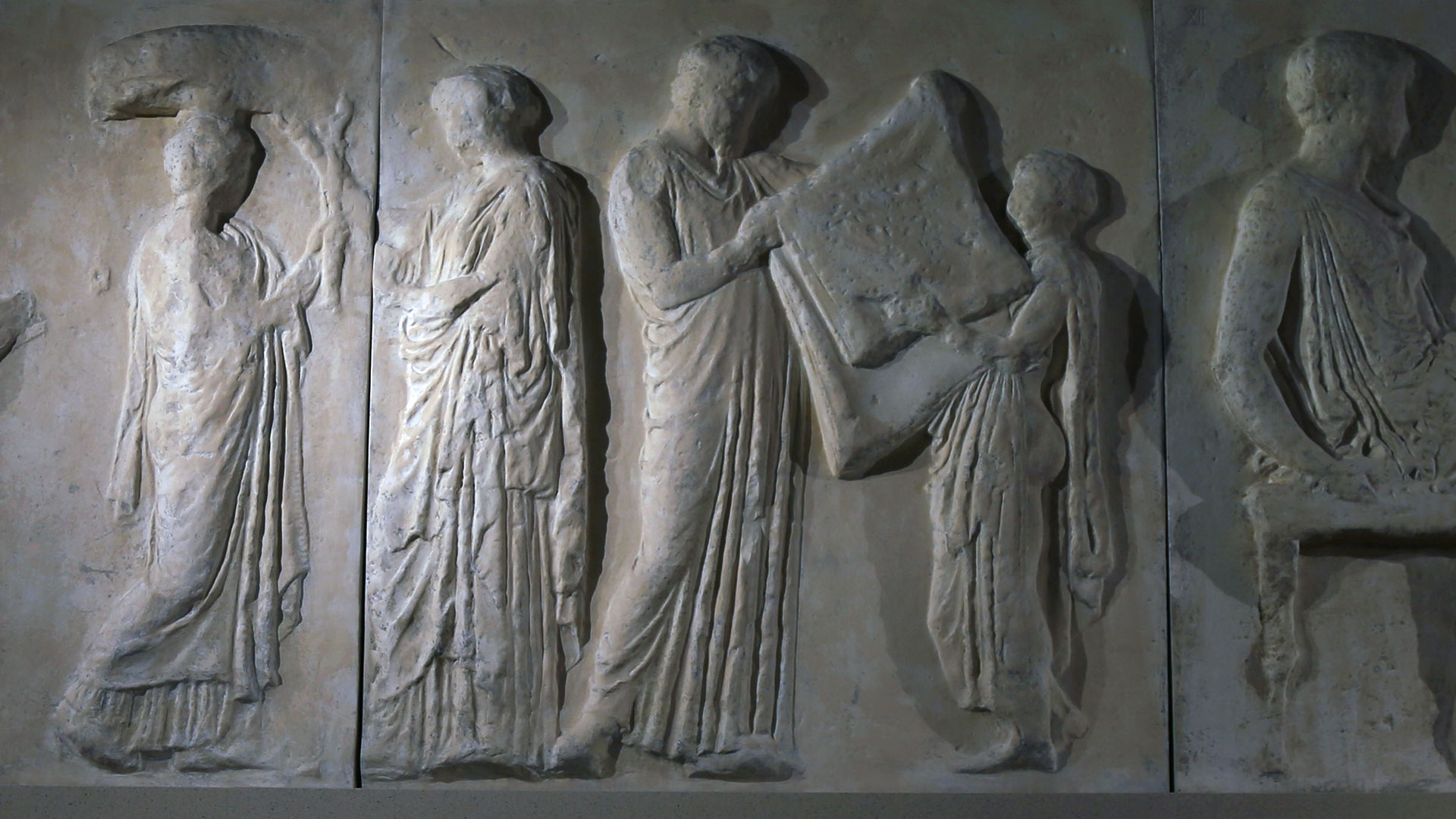 a section of a parthenon plaster cast depicting three people