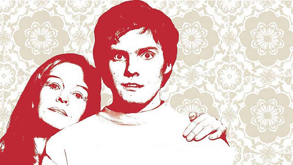 a red and white cutout of a man and woman on a beige background with a floral design