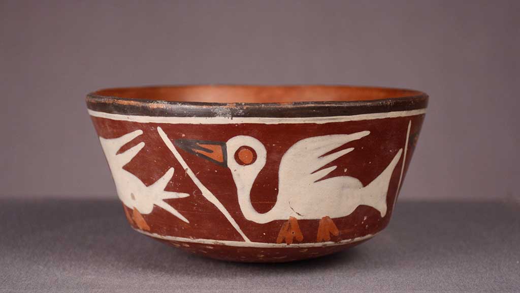 red ceramic bowl with graphic white bird motif