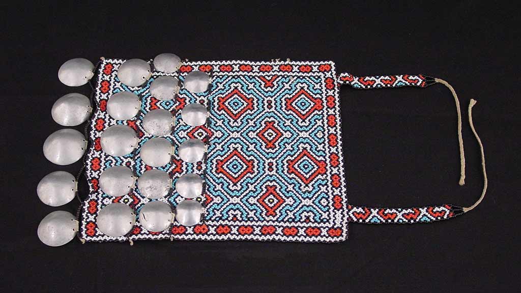 flat cloth with white, blue, and red geometric design, silver discs, and two strings
