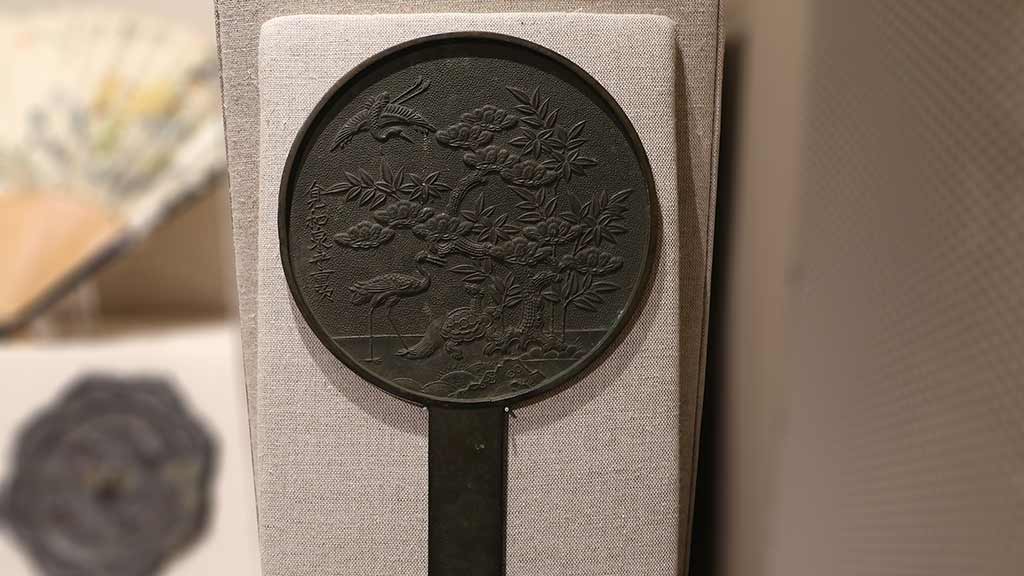 round dark metal mirror with relief of water fowl