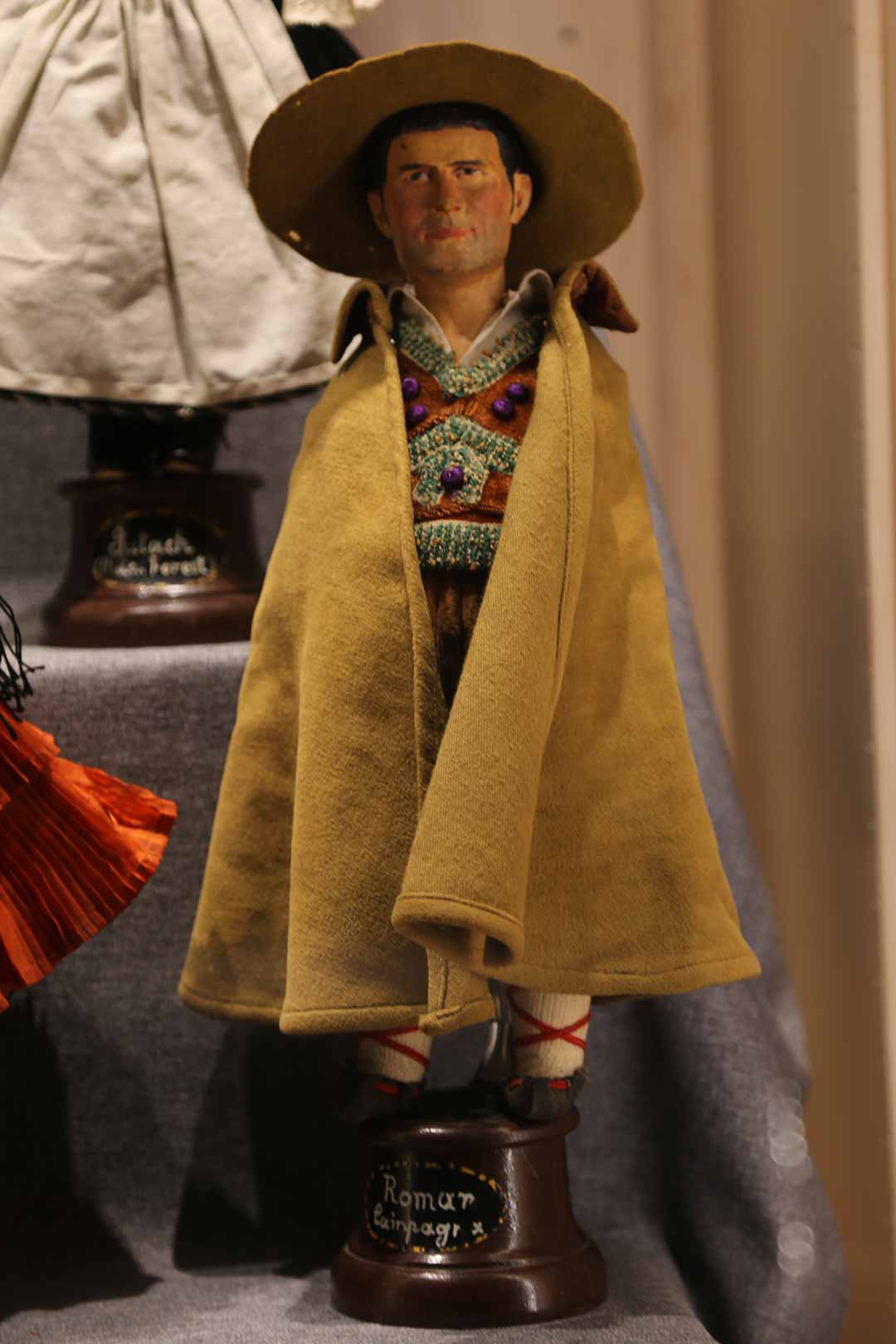 Male doll wearing shawl and hat, labelled Roman