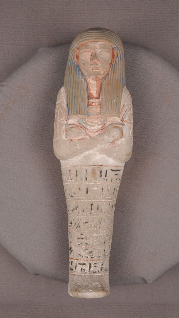 stone carving of a mummified human with paint around the crevises