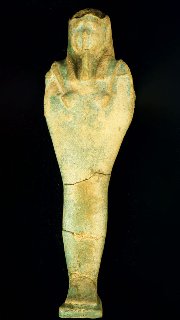 green and yellow stone carving of a mummified human