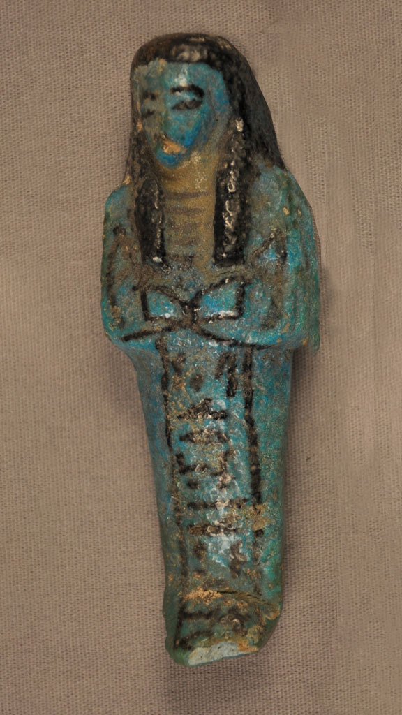 blue green stone carving of a mummified human with black outlining