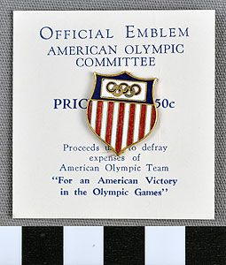Thumbnail of Commemorative Olympic Pin: Official Emblem,  mounted on white paper stock (1977.01.1009S)