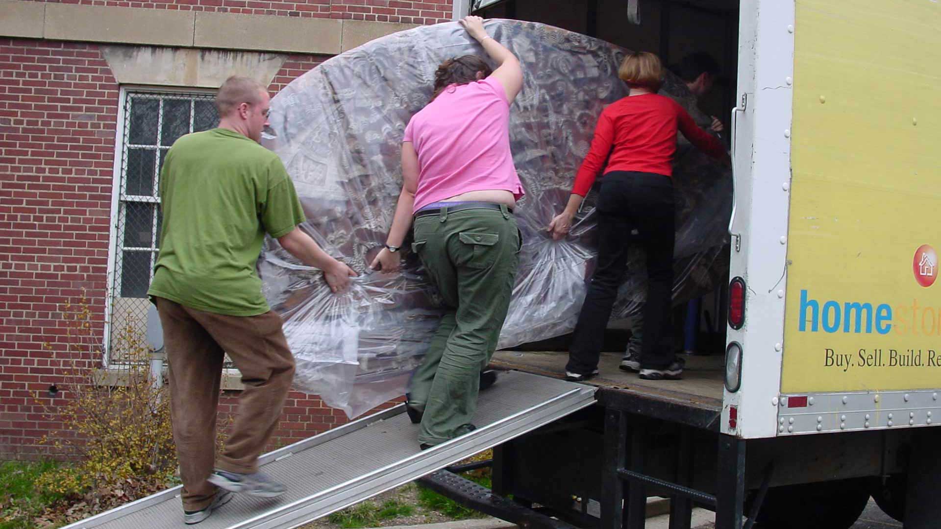 A large artifact being loaded skillfully by three workers
