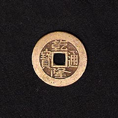 golden brown tinted coin with square cut out in center, surrounding center square hole are Chinese characters