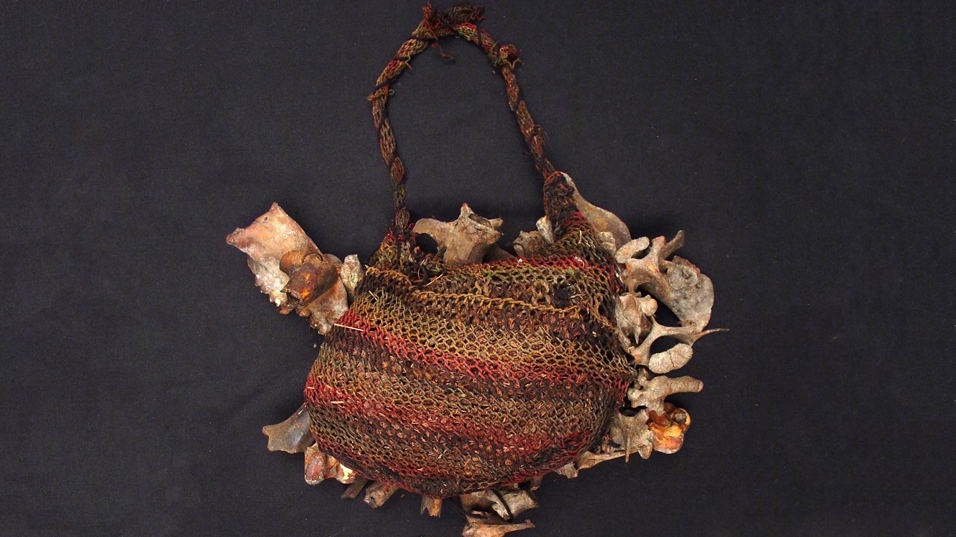 loosely woven bag with attached animal bones