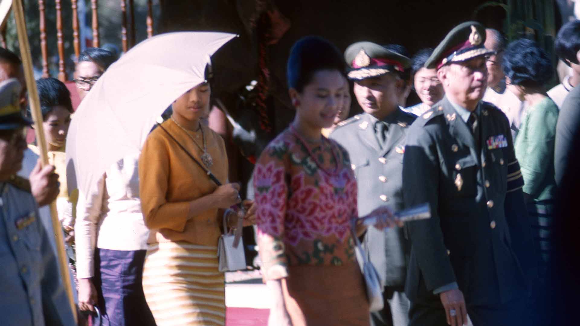 Two women arrive, escorted by military personnel