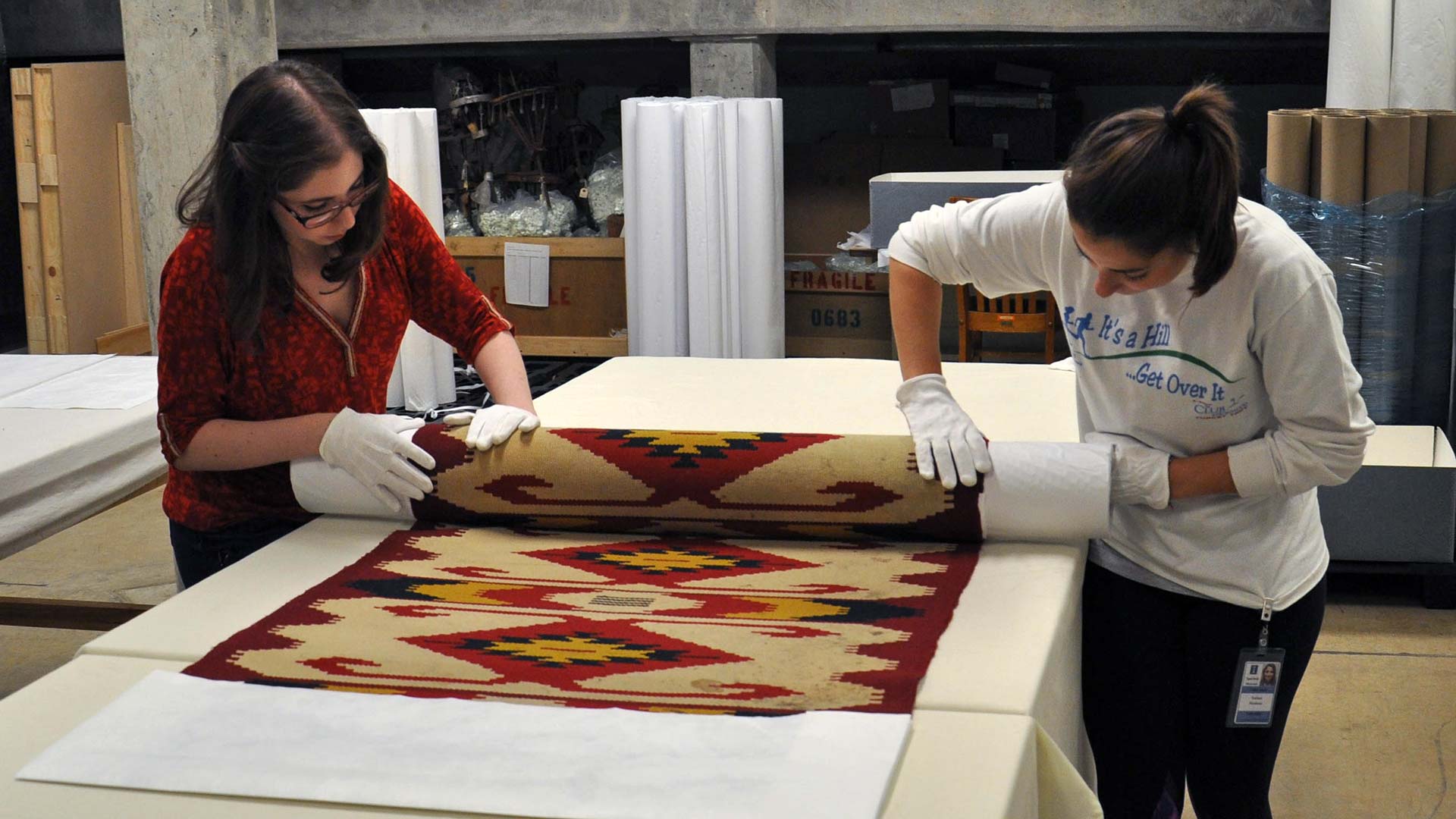 two students roll a textile