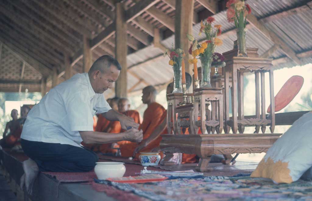 Man kneeling and lighting incense