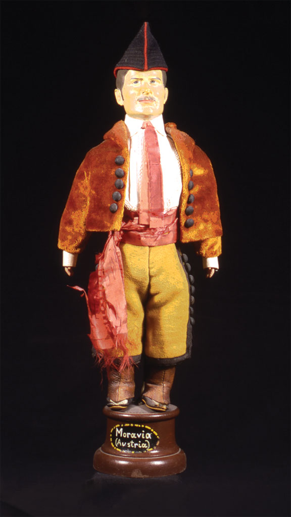 male doll wearing an orange jacket and yellow pants