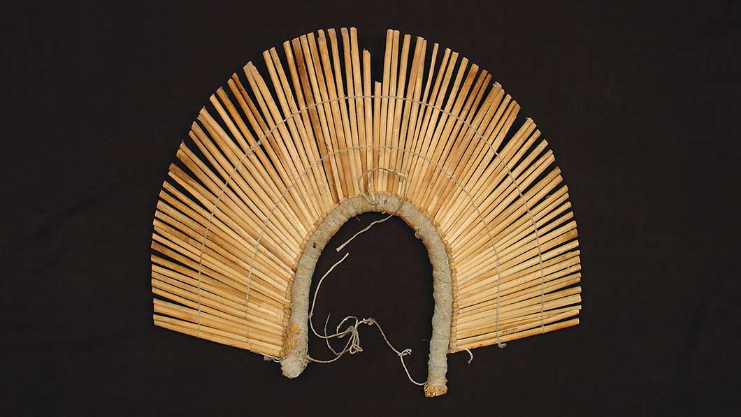 fan-shaped flat headdress made of trimmed sticks that look like reeds