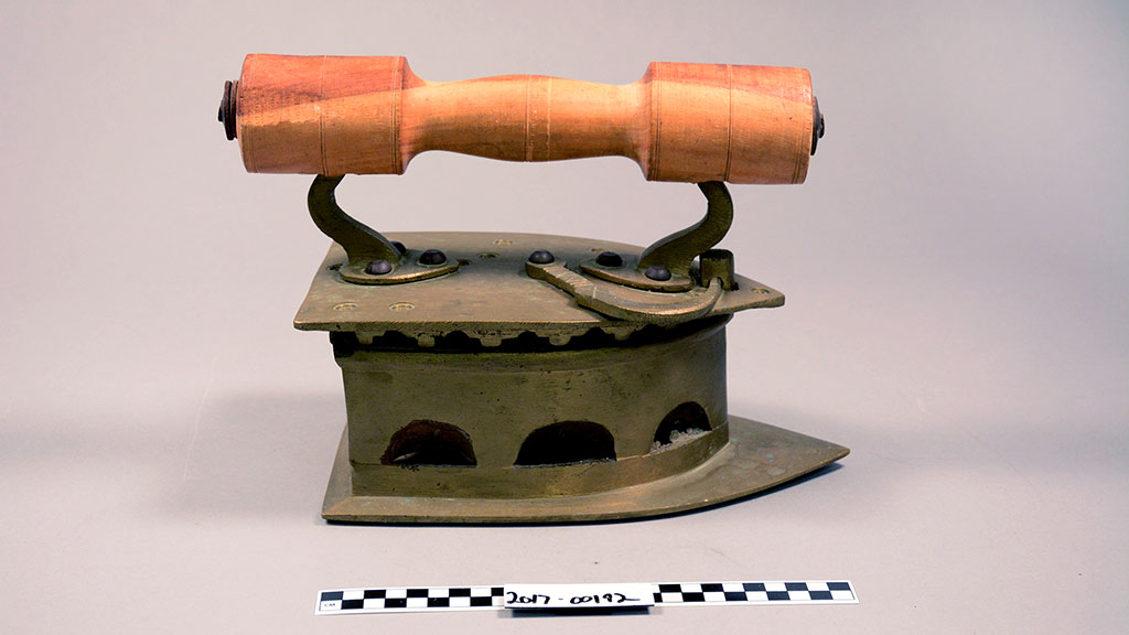 A metal iron with a large handle wooden