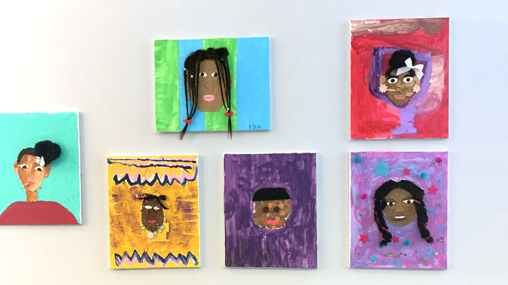 Colorful art made by kids hung up in riverfront museum wall