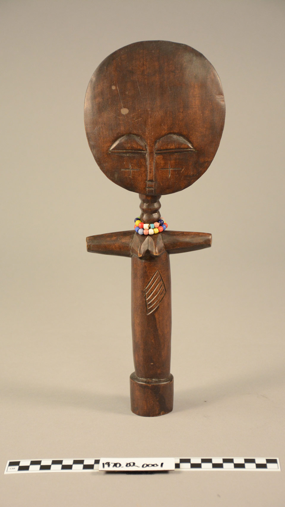 an old African doll made of wood photographed in paper background