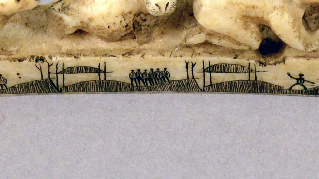 a closeup of the markings of figures and boats on the side of an ivory pipe