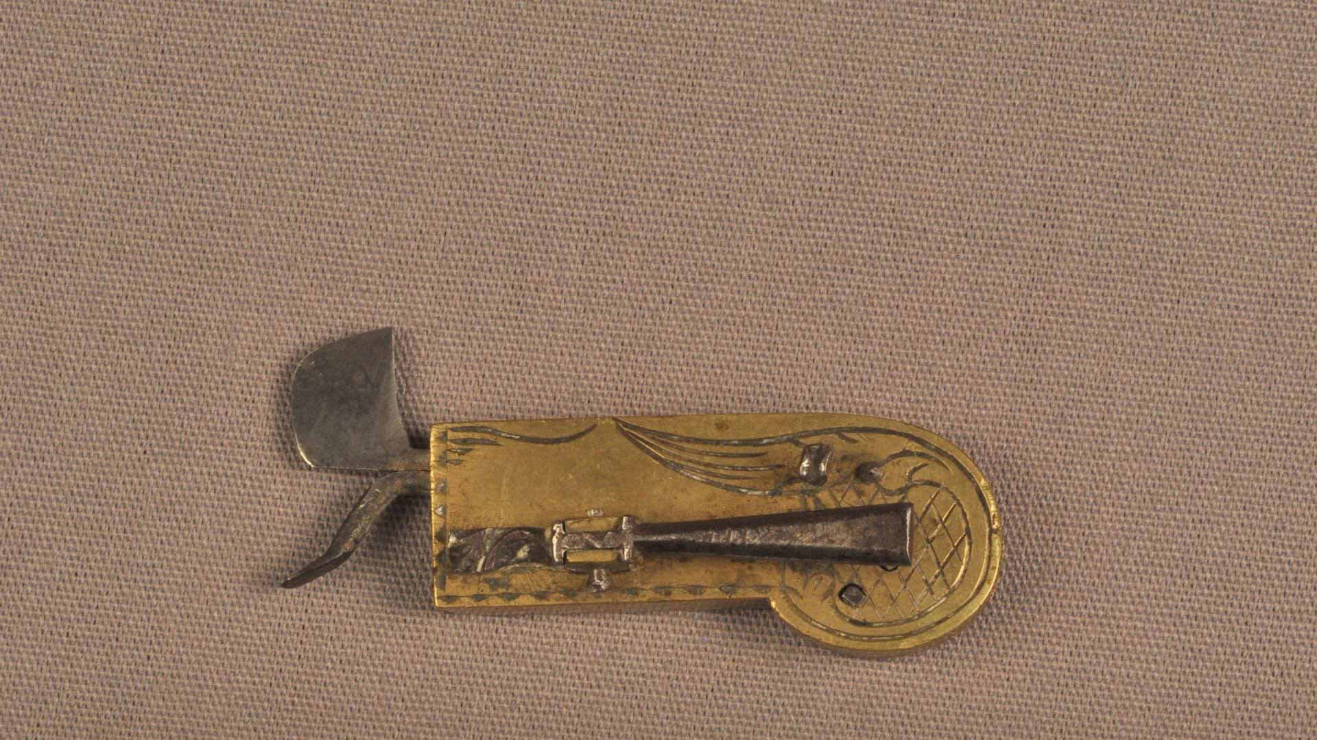 small metal device with a curved metal edge and a slightly curved metal point used for bloodletting