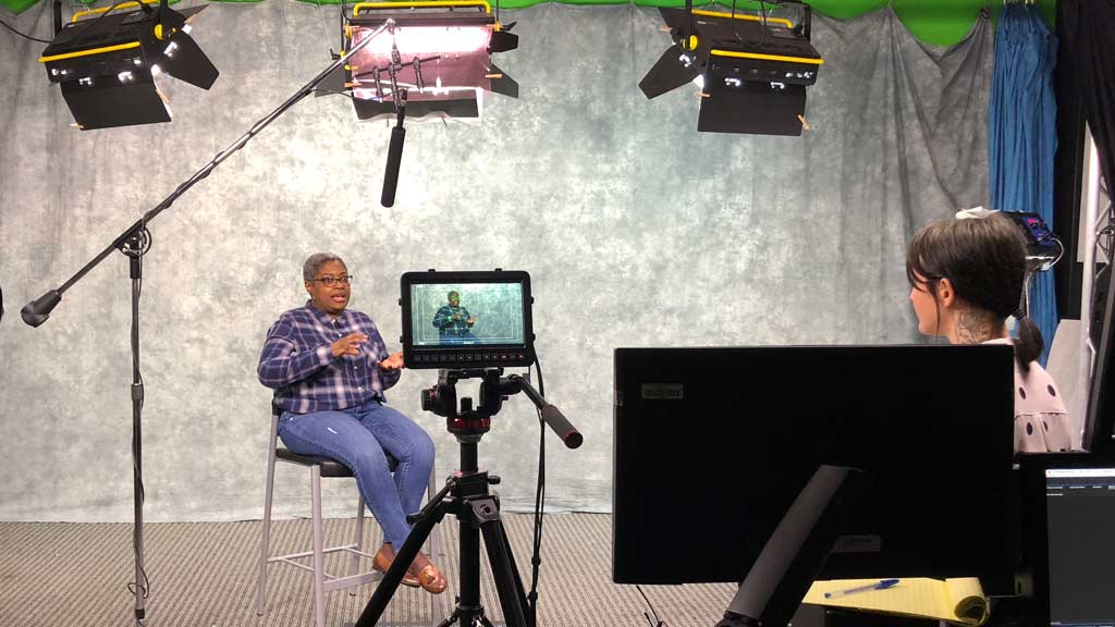 a student interviews a woman in a video production studio