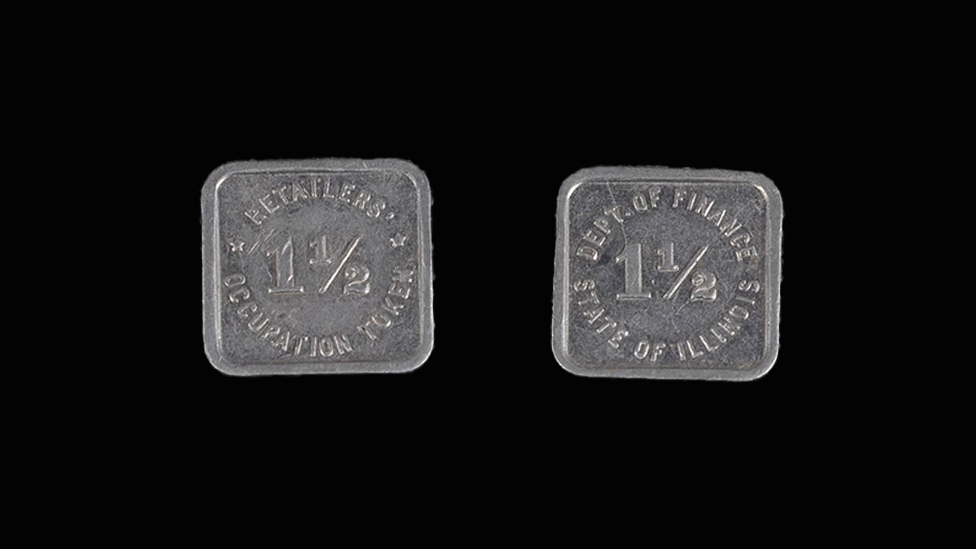the front and back of a small silver square token with the numbers one and a half in the center of it