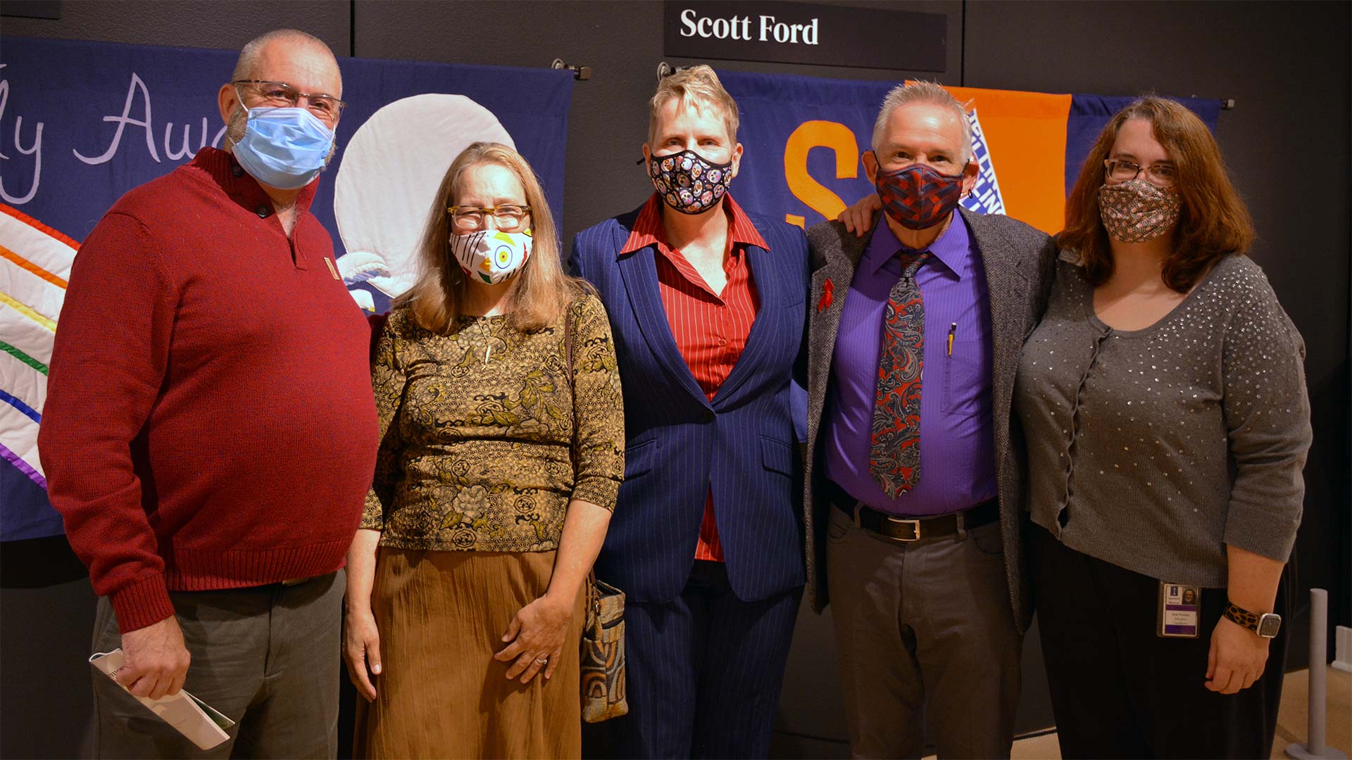 5 people pose with masks in the sewn memory exhibit
