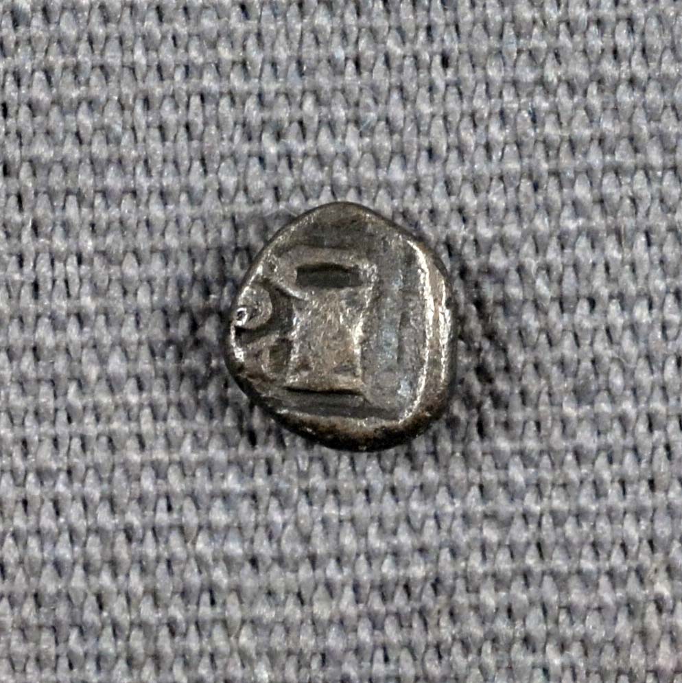 very small grey coin with indiscernable details (alternate side)