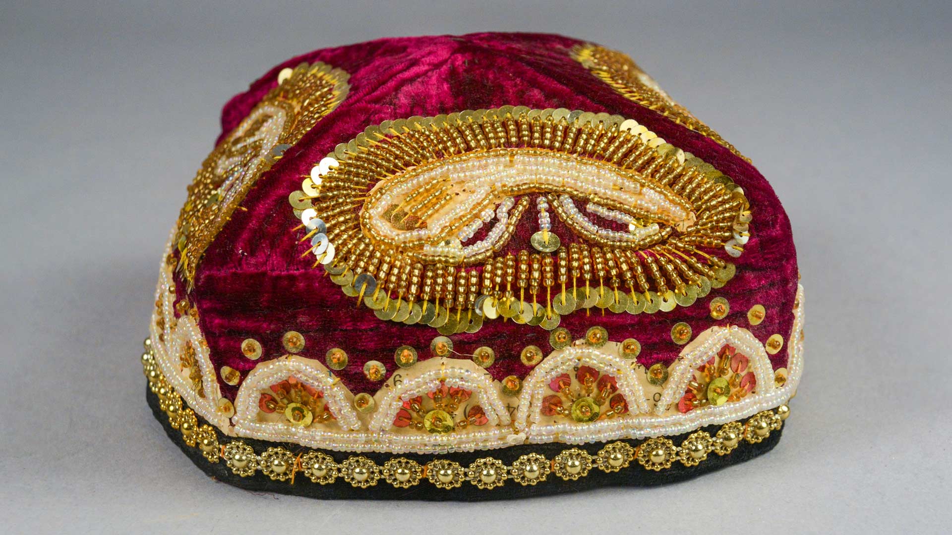 red velvet hat with gold adornments and sequins