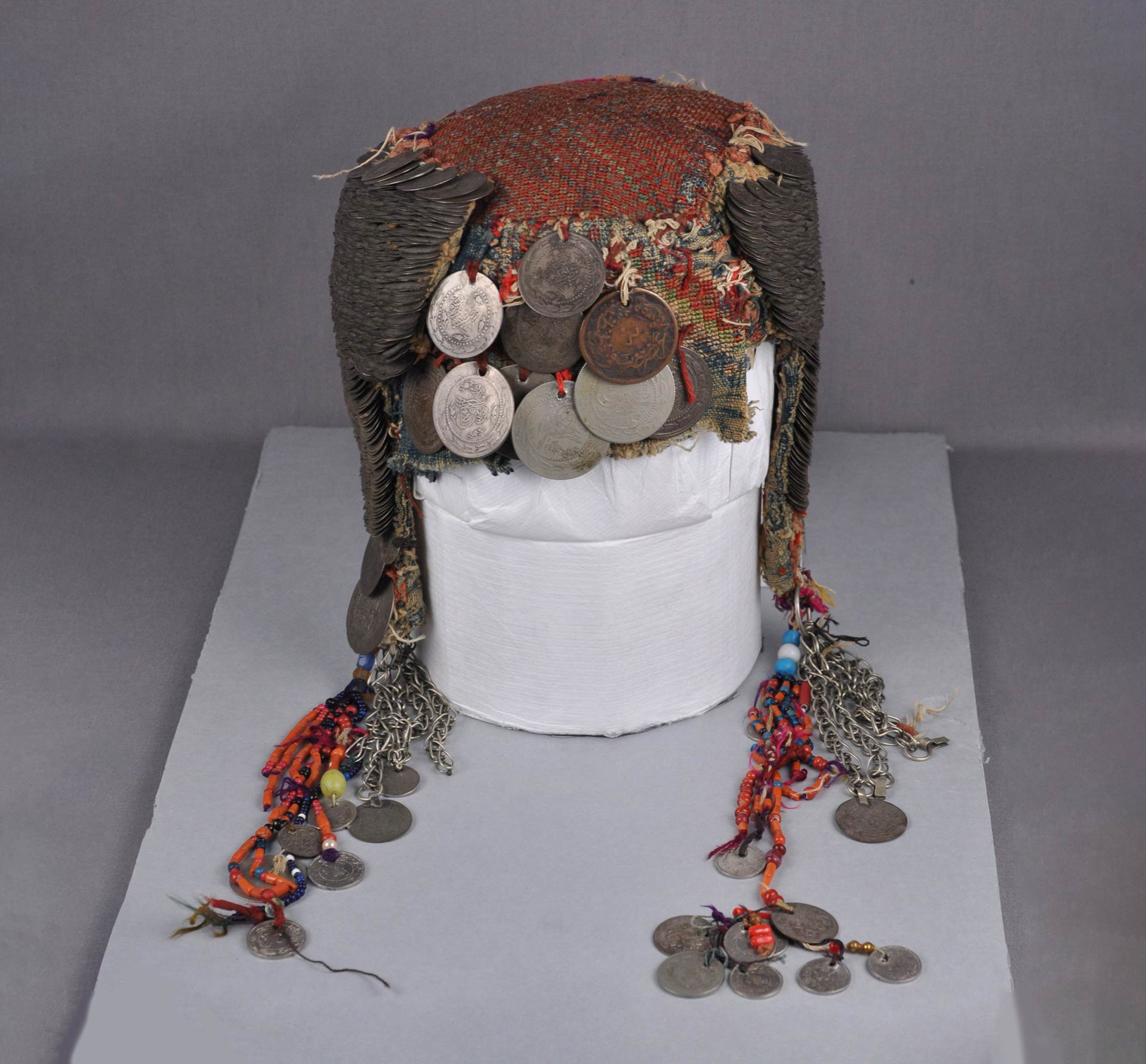 hat with two ear flaps adorned with coins and beads