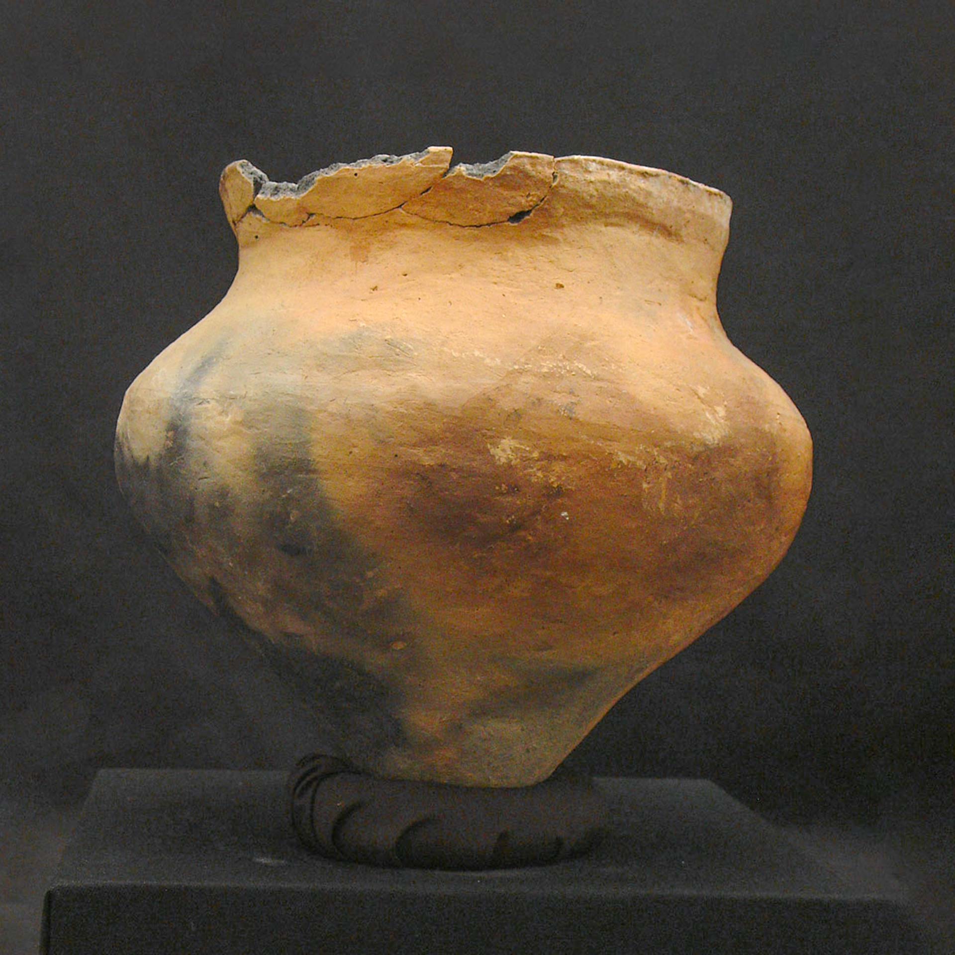 reddish-brown clay pot with black discoloration and a chipped top