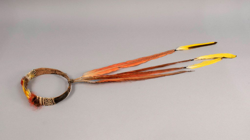headpiece made of a wooden ring and orange and yellow feathers 