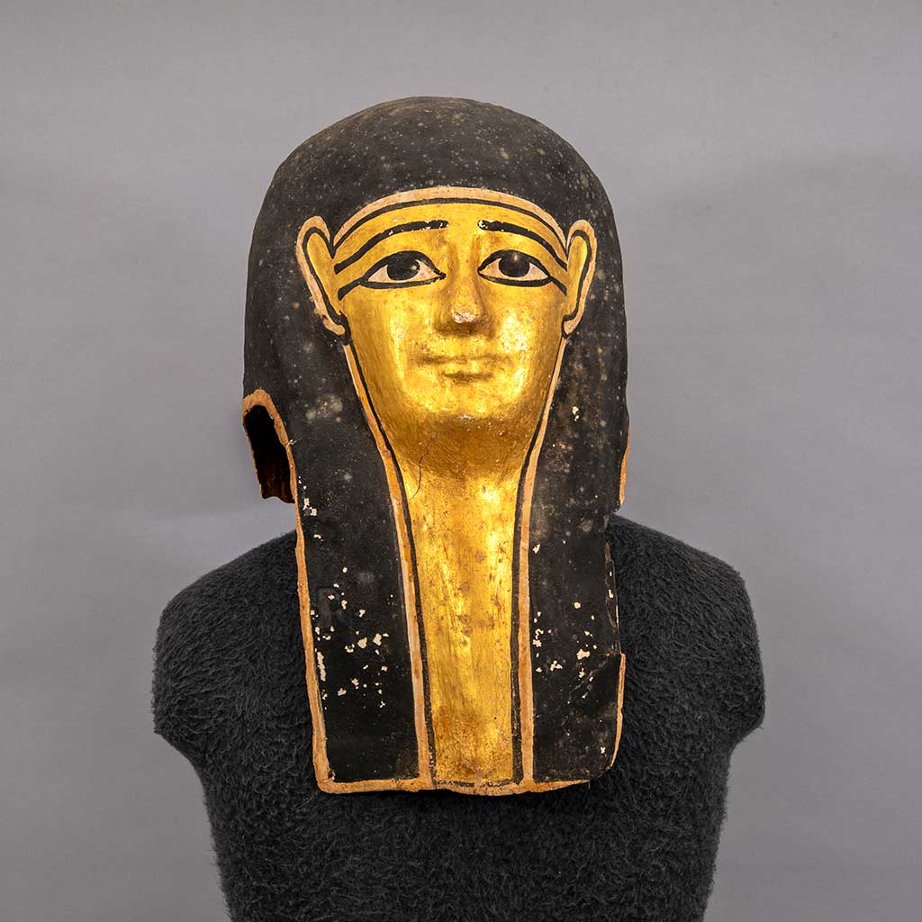 Burial mask depicting a face with gold and black pigment
