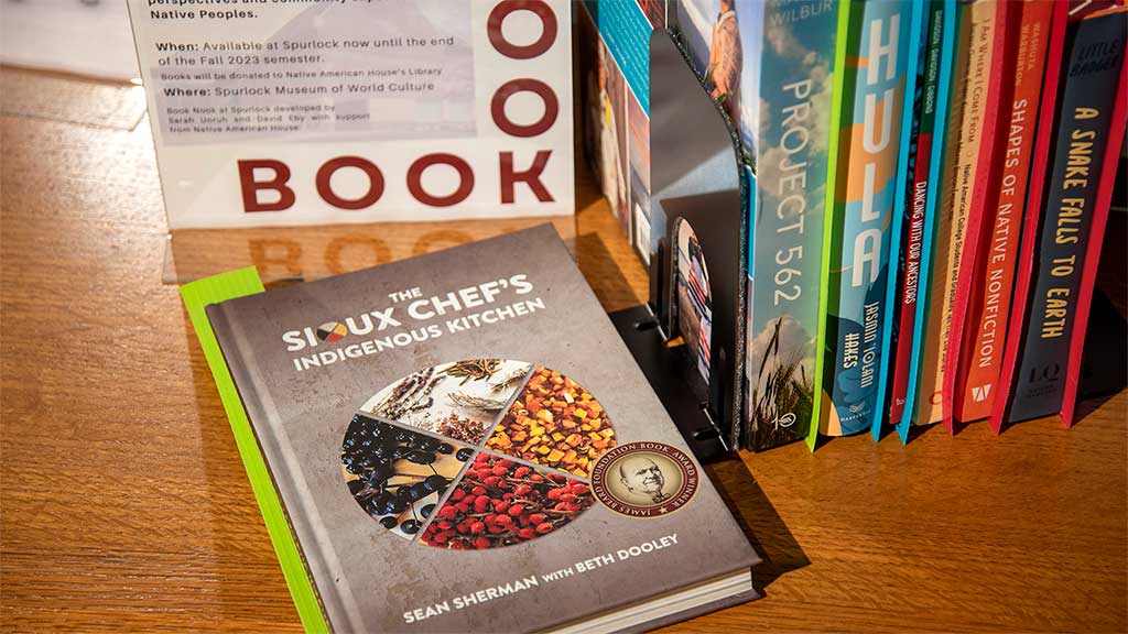 Sioux Cheg's Indigenous Kitchen book on a table with other books to read