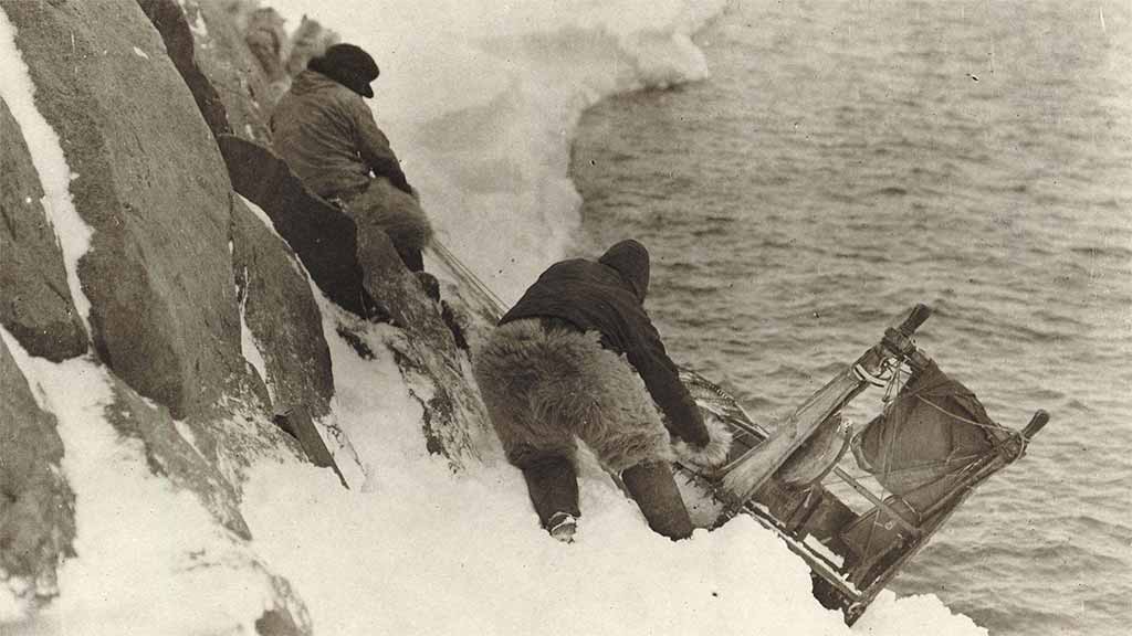 two members of the expedition cling to an ice wall