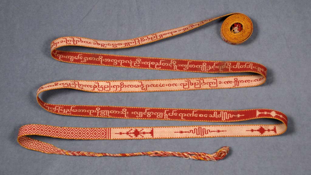long thin embroidered strip of red/pink fabric