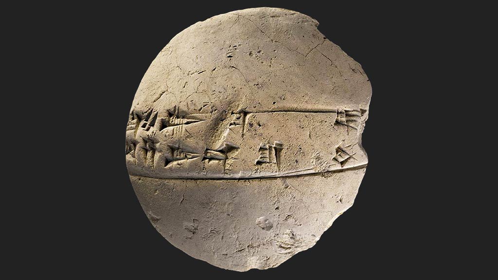round flat stone with cuneiform across the middle