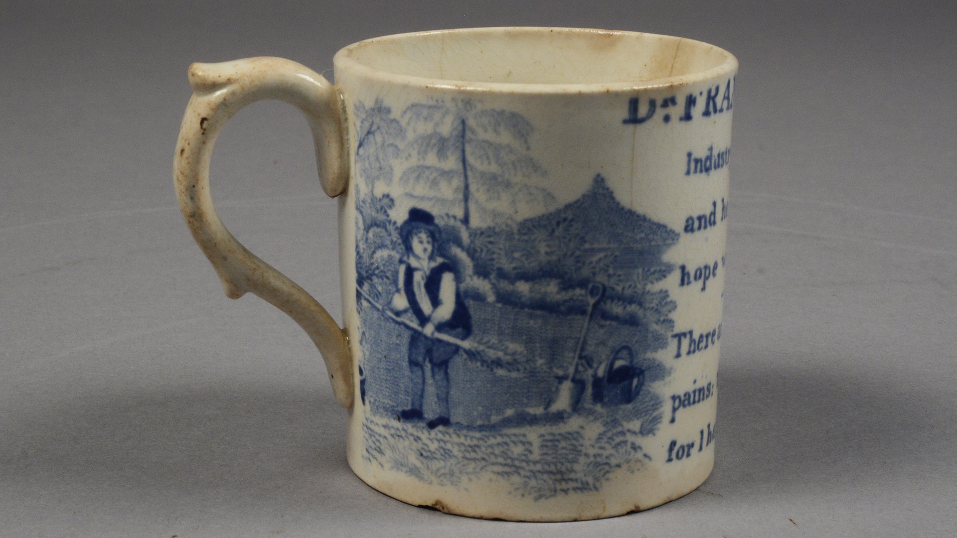A ceramic cup with a blue image of a little boy