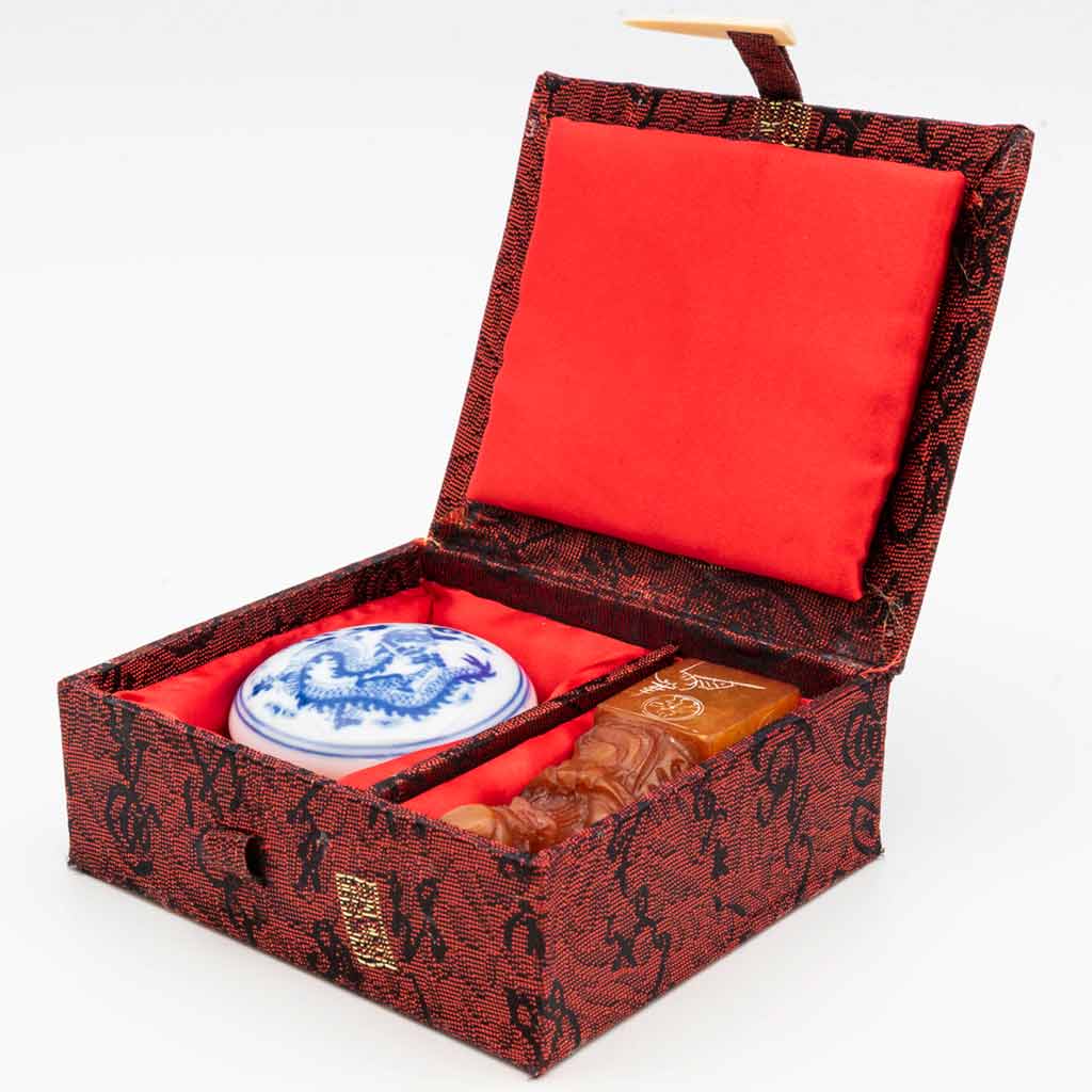 a red box with a stone figure of Shouxing and a chop end with blue calligraphy
