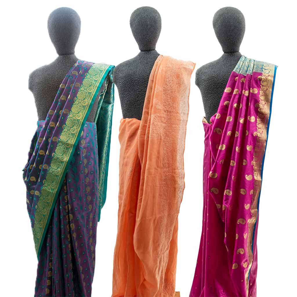 three mannequins with saris in blue, green, orange, and pink.